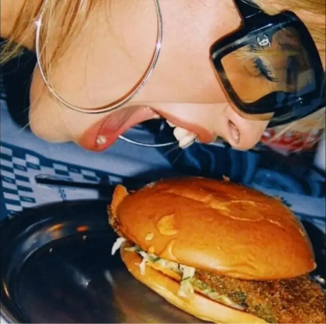 Gros plan sur un burger tenu à deux mains
